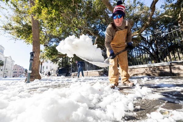 Dylan Gilbert, with the City of Charleston, removes snow in front of City Hall after a winter storm dropped ice and snow Wednesday, Jan. 22, 2025, on Charleston, S.C. (AP Photo/Mic Smith)