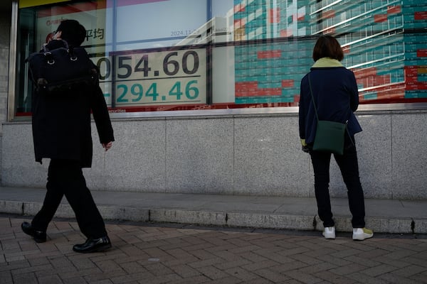 A person looks at an electronic stock board showing Japan's Nikkei index at a securities firm Friday, Nov. 29, 2024, in Tokyo. (AP Photo/Eugene Hoshiko)