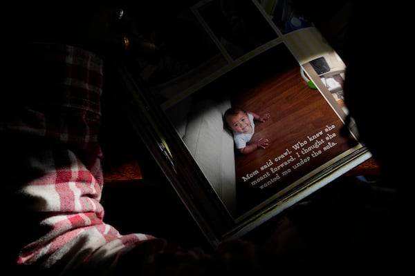 Gianna Young, 7, looks at her big bother Lucas' one-year baby book during a homeschool break in the dining room of their Sunbury, Ohio, home on Tuesday, Nov. 12, 2024. (AP Photo/Carolyn Kaster)