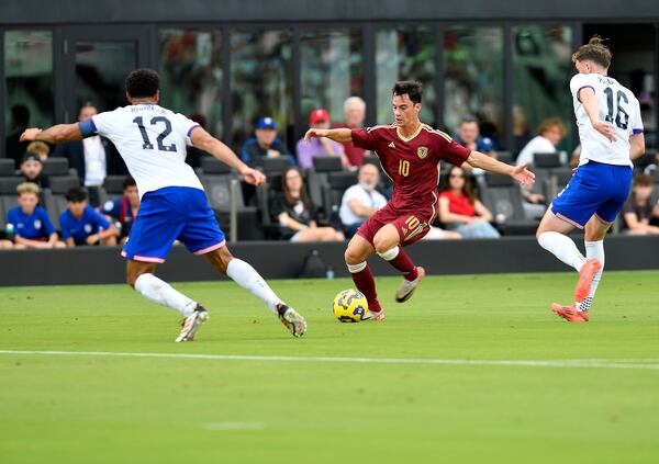 Venezuela midfielder Juan Pablo Añor (10) tries to dribble through United States defender Miles Robinson (12) and midfielder Jack McGlynn (16) during the first half of an international friendly soccer game, Saturday, Jan 18, 2025, in Fort Lauderdale, Fla. (AP Photo/Michael Laughlin)