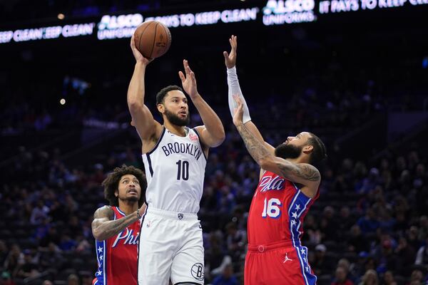 Brooklyn Nets' Ben Simmons, center, goes up for a shot between Philadelphia 76ers' Caleb Martin, right, and Kelly Oubre Jr. during the first half of an Emirates NBA Cup basketball game, Friday, Nov. 22, 2024, in Philadelphia. (AP Photo/Matt Slocum)