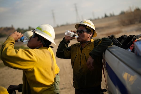 Augustine Secatero, a member of the Navajo Scouts firefighter crew, drinks water while working on the Eaton Fire, Friday, Jan. 17, 2025, in Pasadena, Calif. (AP Photo/John Locher)