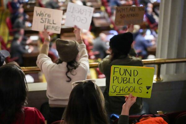 People hold signs over the House floor during a special session of the state legislature Monday, Jan. 27, 2025, in Nashville, Tenn. (AP Photo/George Walker IV)