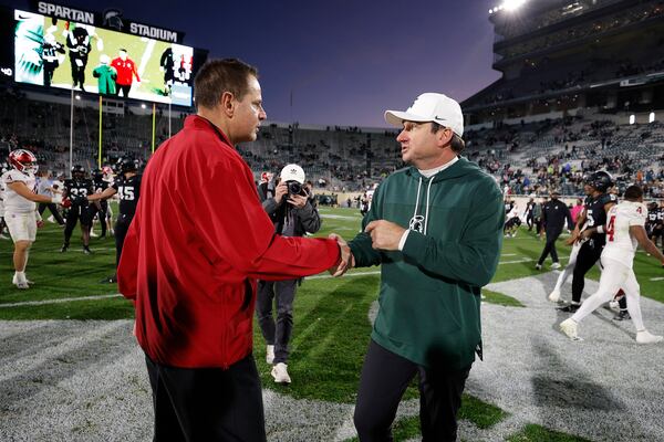 Indiana coach Curt Cignetti, left, and Michigan State coach Jonathan Smith, right, shake hands following an NCAA college football game, Saturday, Nov. 2, 2024, in East Lansing, Mich. (AP Photo/Al Goldis)