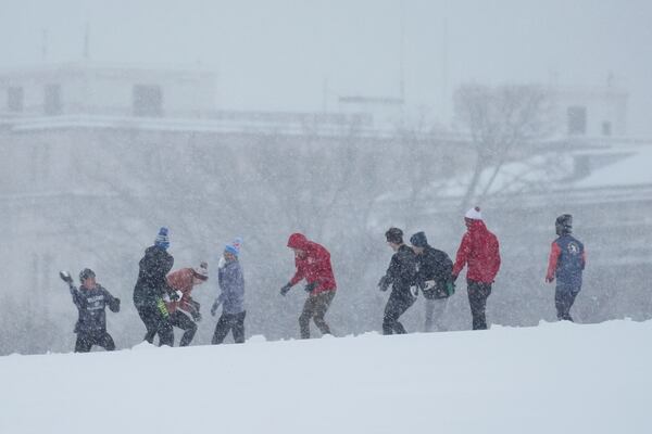 People engage in a snowball fight during a winter snow storm in Washington, Monday, Jan. 6, 2025. (AP Photo/Matt Rourke)