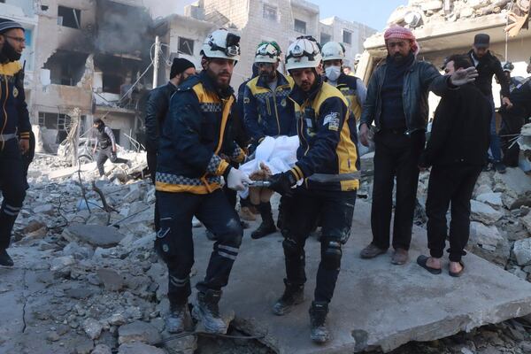 This photo provided by the Syrian Civil Defence White Helmets, which has been authenticated based on its contents and other AP reporting, shows Syrian White Helmets civil defence workers carry a victim after the Syrian government forces hit Idlib city, Syria, Monday, Dec. 2, 2024. (Syrian Civil Defence White Helmets via AP)