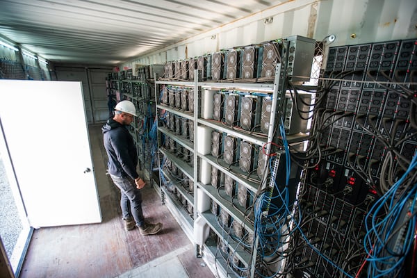 FILE - Chris Radwanski, data center supervisor, checks on Bitcoin mining machines in a shipping container behind the Scrubgrass Power plant in Russellton, Pa., July 23, 2021. (Andrew Rush/Pittsburgh Post-Gazette via AP, File)