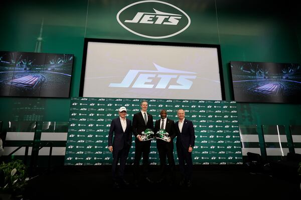 New York Jets owner Woody Johnson, left, and vice chairman Christopher Johnson, right, pose for a photo with new head coach Aaron Glenn, second right, and general manager Darren Mougey during a press conference at the NFL football team's training facility on Monday, Jan. 27, 2025, in Florham Park, N.J. (AP Photo/Adam Hunger)