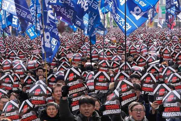 Protesters stage a rally to demand South Korean President Yoon Suk Yeol's impeachment in Seoul, South Korea, Thursday, Dec. 12, 2024. The signs read "Disband the ruling People Power Party." (AP Photo/Ahn Young-joon)