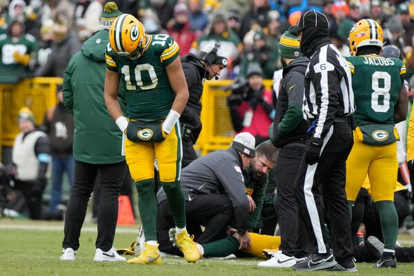 Green Bay Packers quarterback Jordan Love (10) reacts as wide receiver Christian Watson, bottom, is checked on during the first half of an NFL football game against the Chicago Bears, Sunday, Jan. 5, 2025, in Green Bay, Wis. (AP Photo/Morry Gash)