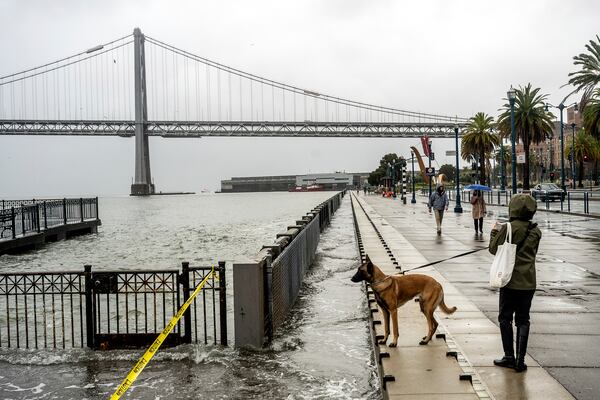 Water from the San Francisco Bay spills onto the Embarcadero in San Francisco on Saturday, Dec. 14, 2024, as a result of high tides and storm-driven waves. (AP Photo/Noah Berger)