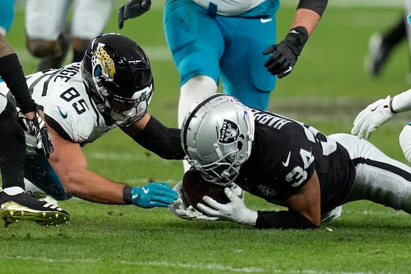 Las Vegas Raiders safety Thomas Harper (34) recovers a rumble against Jacksonville Jaguars tight end Brenton Strange (85) during the first half of an NFL football game Sunday, Dec. 22, 2024, in Las Vegas. (AP Photo/John Locher)