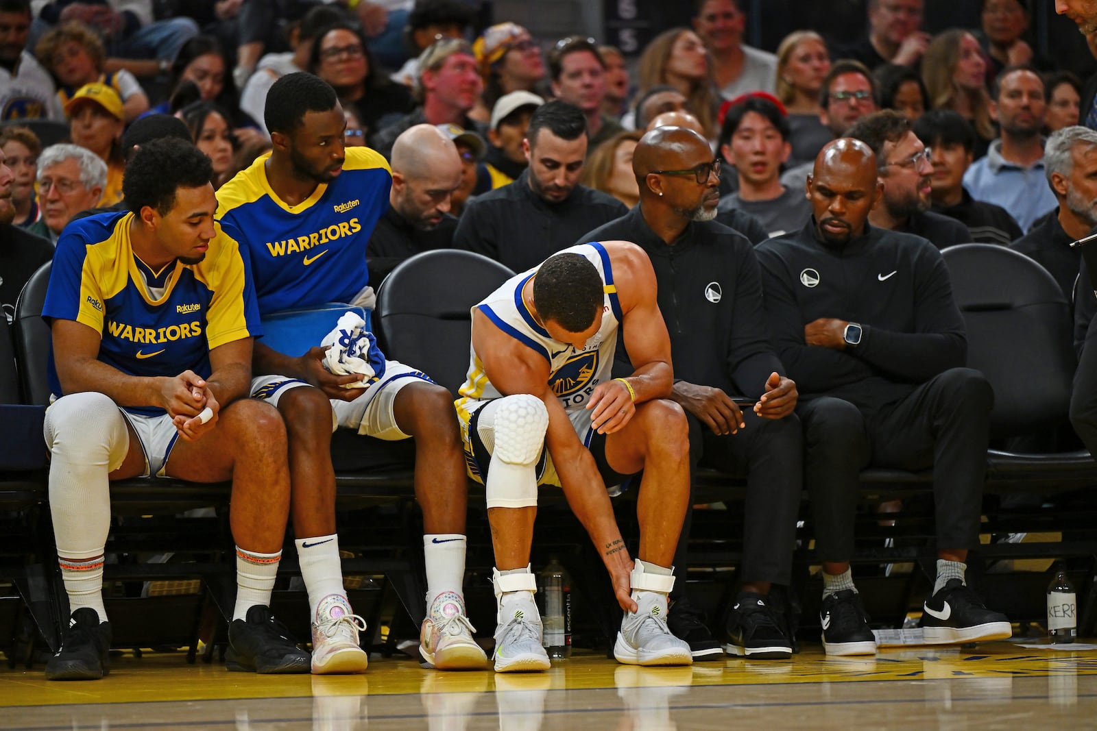 Golden State Warriors' Stephen Curry, center, holds his left ankle after sustaining an injury in the third quarter of an NBA basketball game against the Los Angeles Clippers in San Francisco, Sunday, Oct. 27, 2024. (Jose Carlos Fajardo/Bay Area News Group via AP)