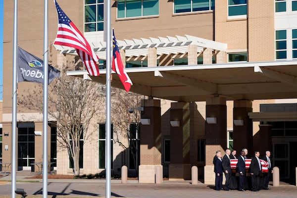 Former and current U.S. Secret Service agents assigned to the Carter detail, move the flag-draped casket of former President Jimmy Carter, at Phoebe Sumter Medical Center in Americus, Ga., Saturday, Jan. 4, 2025. Carter died Dec. 29 at the age of 100. (AP Photo/Alex Brandon, Pool)