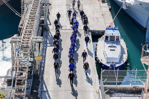 An aerial photograph taken by a drone shows migrants escorted by Italian police going for processing following earlier court rejections, in the port of Shengjin, northwestern Albania, Tuesday, Jan. 28, 2025. (AP Photo/Vlasov Sulaj)