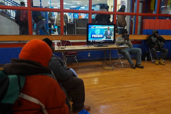 Patrons watch a local weather report while sheltering from the cold inside a recreation center, Monday, Jan. 6, 2025, in Cincinnati. (AP Photo/Joshua A. Bickel)