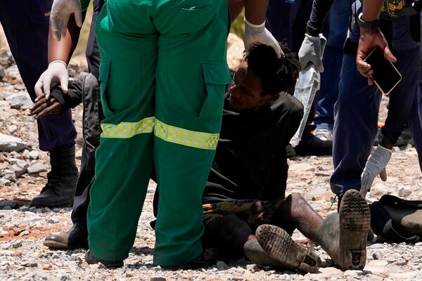 A miner is assisted by rescue workers after he was rescued from below ground in an abandoned gold mine in Stilfontein, South Africa, Tuesday, Jan. 14, 2025. (AP Photo/Themba Hadebe)