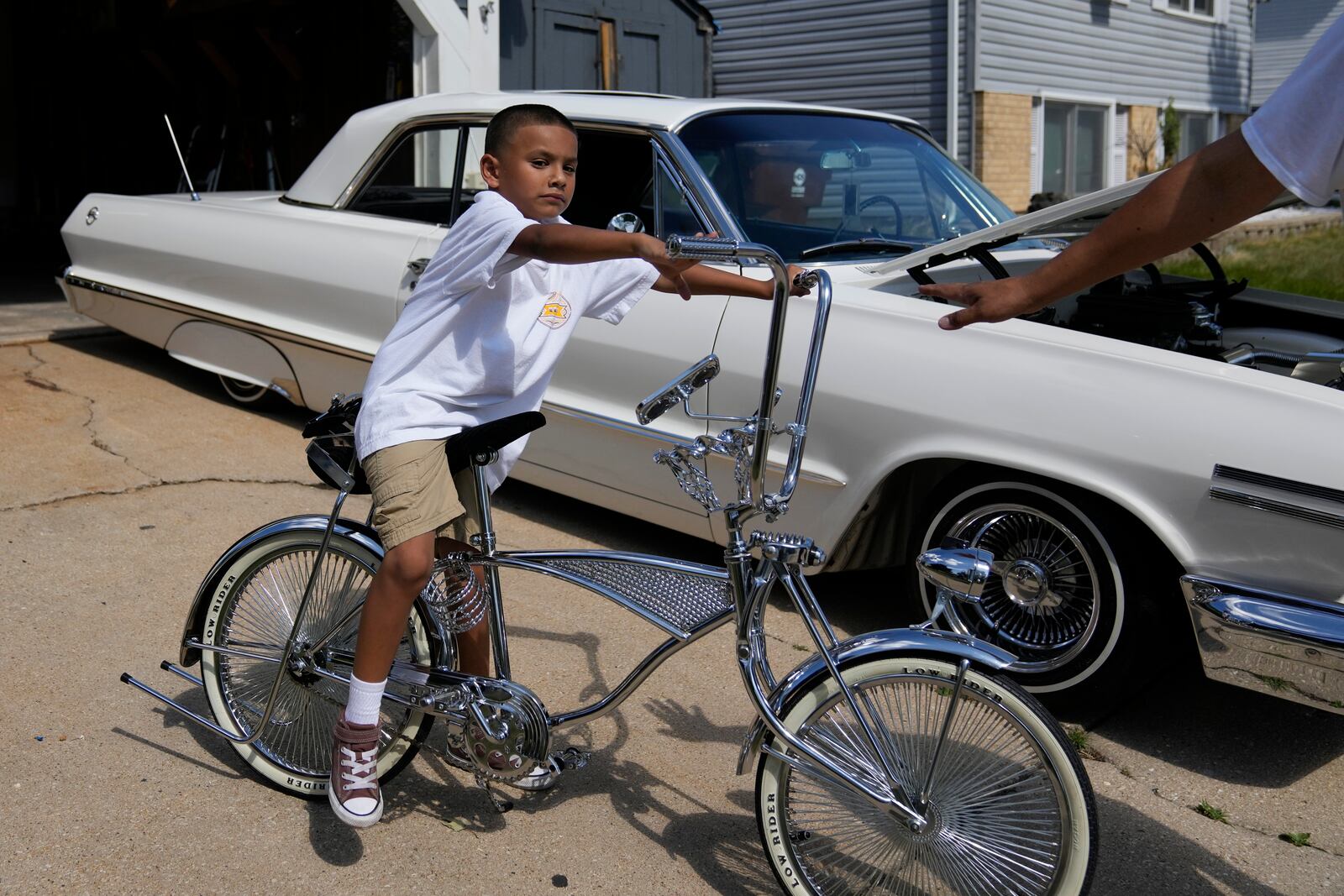 Seven-year-old Daniel Marquez sits on his chrome lowrider bike, custom-built by himself and family friends in memory of his late father Alberto, a longtime member of lowrider car clubs, Saturday, Sept. 14, 2024, at his home in Frankfort, Ill. (AP Photo/Erin Hooley)