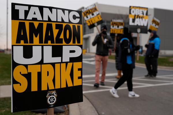 Strikers hold signs during a strike at Skokie (DIL7) Amazon Delivery station in Skokie, Ill., Thursday, Dec. 19, 2024. (AP Photo/Nam Y. Huh)