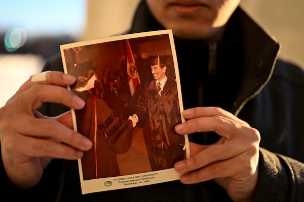 Ibrahim Almadi holds a photo of his father Saad Almadi graduating from college in 1984, in Washington Monday, Dec. 23, 2024. Saad Almadi, a dual U.S.-Saudi citizen was jailed for social media posts critical of the kingdom's crown prince. He was released from a Saudi prison in March 2023 and banned from returning to his home in south Florida. (AP Photo/John McDonnell)