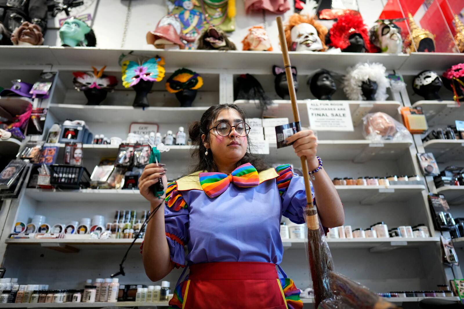 Hamida Mokhtar prices merchandise at The Theatrical Shop, Tuesday, Oct. 29, 2024, in West Des Moines, Iowa. (AP Photo/Charlie Neibergall)