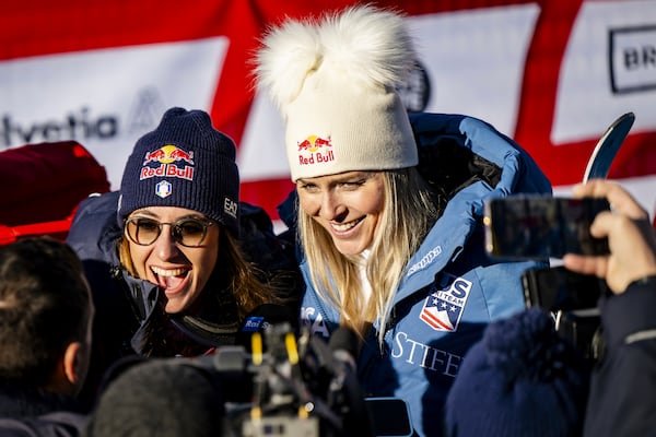 Sofia Goggia of Italy, left, and Lindsey Vonn of United States of America, talk with journalists after completing an alpine ski, women's World Cup super G, in St. Moritz, Switzerland, Saturday, Dec. 21, 2024. (Jean-Christophe Bott/Keystone via AP)