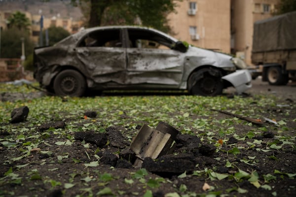 A rocket, fired from Lebanon during the night hours before the start of the ceasefire, sits wedged in the ground next to a damaged car in Kiryat Shmona, northern Israel, Wednesday, Nov. 27, 2024. (AP Photo/Leo Correa)