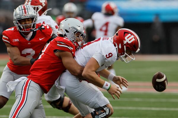 Ohio State defensive back Lathan Ransom, center, sacks Indiana quarterback Kurtis Rourke causing a fumble during the first half of an NCAA college football game Saturday, Nov. 23, 2024, in Columbus, Ohio. (AP Photo/Jay LaPrete)