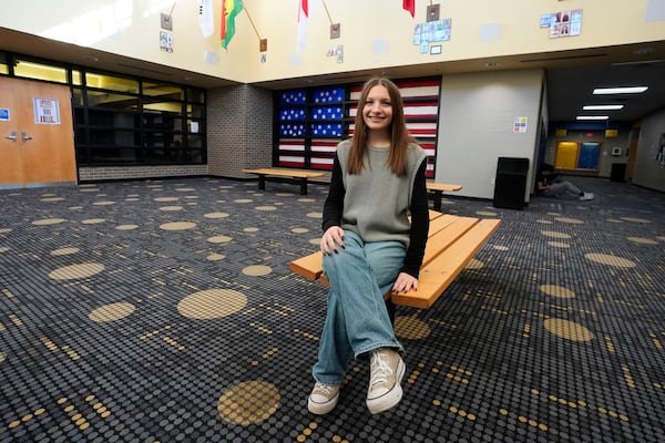 Makenzie Gilkison sits in the lobby at Greenfield Central High School, Tuesday, Dec. 17, 2024, in Greenfield, Ind. (AP Photo/Darron Cummings)