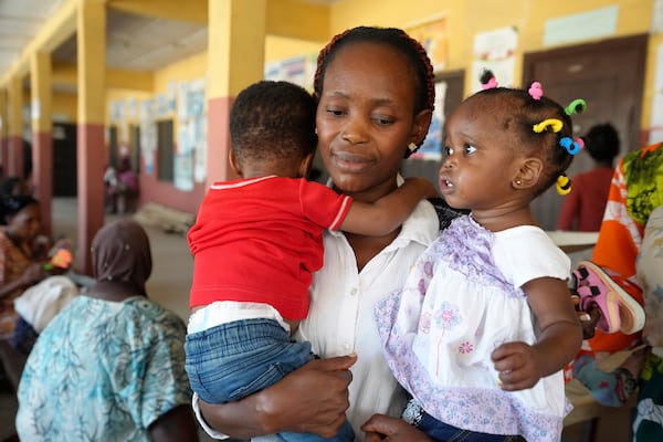 A woman waits to have the malaria vaccine R21/Matrix-M administered to her children at the comprehensive Health Centre in Agudama-Epie, in Yenagoa, Nigeria, Monday, Dec. 9, 2024. (AP Photo/Sunday Alamba)