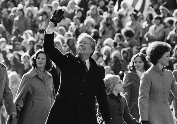 FILE - President Jimmy Carter waves to the crowd while walking with his wife Rosalynn and their daughter Amy along Pennsylvania Avenue from the Capitol to the White House following his inauguration, Jan. 20, 1977, in Washington. (AP Photo/Suzanne Vlamis, File)