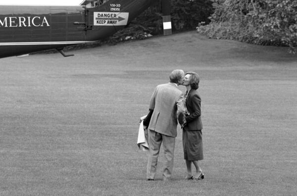 FILE - President Jimmy Carter pauses to kiss his wife, first lady Rosalynn Carter, as he boards a helicopter in Washington for a trip from the White House to Camp David, Md., May 10, 1979. (AP Photo/Barry Thumma, File)