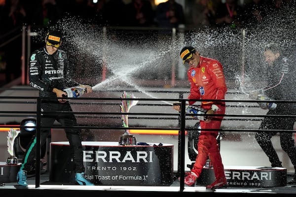 Mercedes driver George Russell, of Britain, left, sprays champagne on Ferrari driver Carlos Sainz, of Spain, after the F1 Las Vegas Grand Prix auto race, Saturday, Nov. 23, 2024, in Las Vegas.(AP Photo/Rick Scuteri)