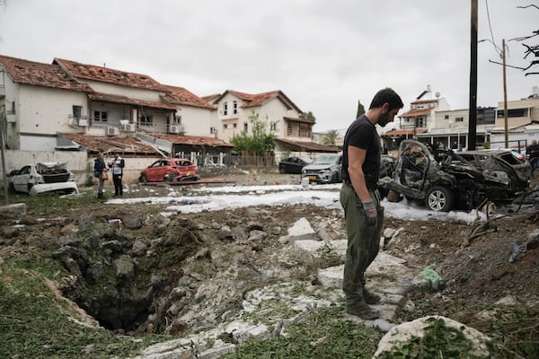 Israeli police bomb squad inspect the site after a missile fired from Lebanon hit the area in Petah Tikva, outskirts of Tel Aviv, Israel, Sunday Nov. 24, 2024. (AP Photo/Oded Balilty)