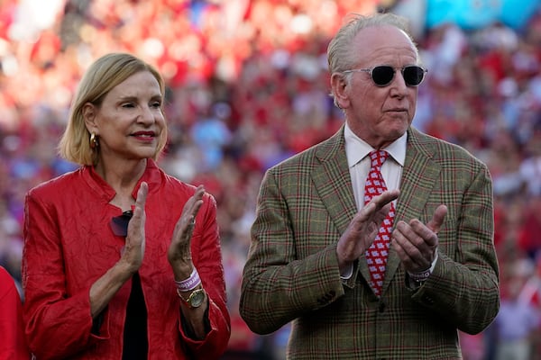 FILE - Former Mississippi and New Orleans Saints quarterback and father of former Mississippi and New York Giants quarterback Eli Manning, right and his wife Olivia Manning, applaud their son Eli, as he addresses the crowd during the retirement ceremony for his football jersey, number 10, during an NCAA college football game against LSU in Oxford, Miss., on Oct. 23, 2021. (AP Photo/Rogelio V. Solis, File)