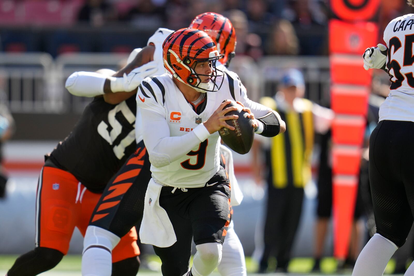 Cincinnati Bengals quarterback Joe Burrow (9) scrambles in the first half of an NFL football game against the Cleveland Browns, Sunday, Oct. 20, 2024, in Cleveland. (AP Photo/Sue Ogrocki)