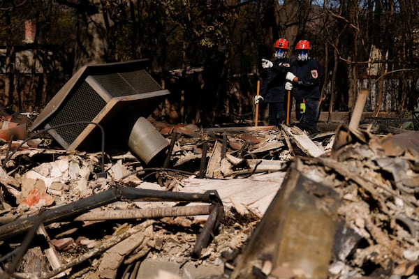 Members of a San Bernardino County Fire Department Search and Rescue crew work among the ruins of the Palisades Fire in the Pacific Palisades neighborhood of Los Angeles, Tuesday, Jan. 14, 2025. (AP Photo/Carolyn Kaster)