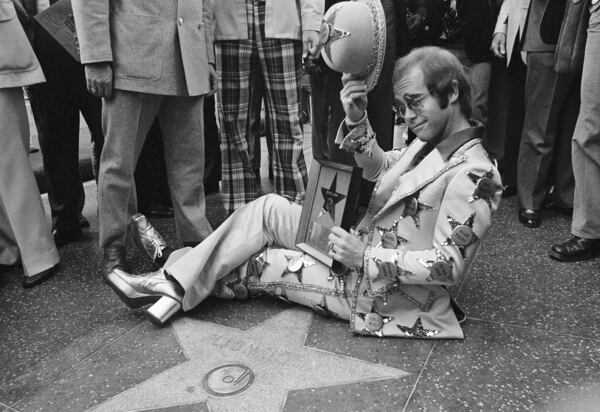 FILE - Elton John poses at his star on the Walk of Fame in Los Angeles on Oct. 23, 1975. (AP Photo/Jeff Robbins, File)