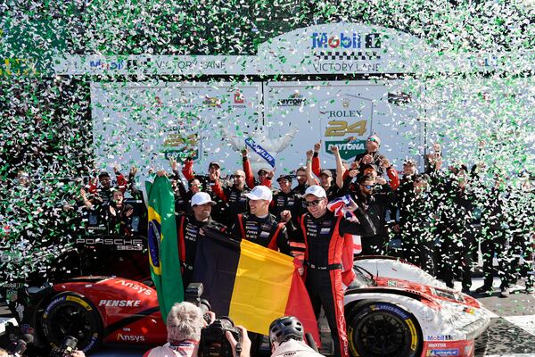 Porsche Penske Motorsport team drivers, from left to right, Brazil's Felipe Nasr, Belgium's Laurens Vanthoor and Britain's Nick Tandy celebrate in Victory Lane after winning the IMSA Rolex 24 hour auto race at Daytona International Speedway, Sunday, Jan. 26, 2025, in Daytona Beach, Fla. (AP Photo/John Raoux)