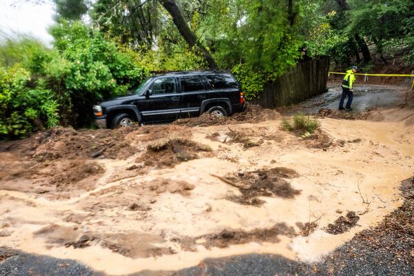 A firefighter evaluates a mudslide as heavy rains fall near Healdsburg in unincorporated Sonoma County, Calif., Friday, Nov. 22, 2024. (AP Photo/Noah Berger)