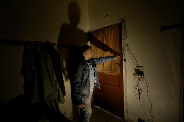 Hussein Arbeeni, 41, shows how he blocked a room door by tapes where 23 people locked themselves inside it to prevent leakage of the sarin struck during a 2013 chemical weapons attack that was blamed on then President Bashar Assad's forces, in Zamalka neighbourhood, on the outskirts of Damascus, Syria, Wednesday, Dec. 25, 2024. (AP Photo/Hussein Malla)