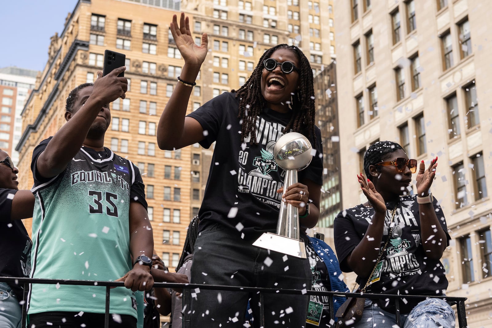 Members of the New York Liberty, including Jonquel Jones holding the MVP trophy, makes their way up Broadway during the WNBA basketball championship parade Thursday, Oct. 24, 2024, in New York. (AP Photo/Yuki Iwamura)