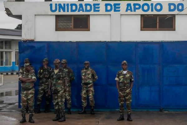 Soldiers watch President Joe Biden's motorcade drive through Luanda, Angola, Tuesday, Dec. 3, 2024. (AP Photo/Ben Curtis)