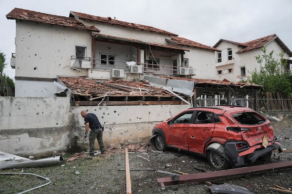 Israeli police bomb squad inspect the site after a missile fired from Lebanon hit the area in Petah Tikva, outskirts of Tel Aviv, Israel, Sunday Nov. 24, 2024. (AP Photo/Oded Balilty)