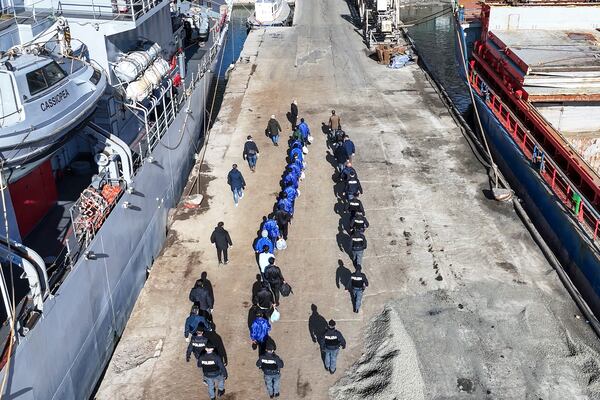 An aerial photograph taken by a drone shows migrants escorted by Italian police going for processing following earlier court rejections, in the port of Shengjin, northwestern Albania, Tuesday, Jan. 28, 2025. (AP Photo/Vlasov Sulaj)