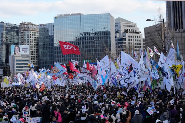 Protesters carry flags during a rally demanding immediate indictment of impeached South Korean President Yoon Suk Yeol in Seoul, South Korea, Saturday, Jan. 25, 2025. (AP Photo/Ahn Young-joon)