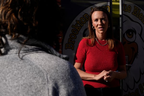 Kelli Ferrone speaks with a group of fellow parents outside a temporary school their kids are attending Friday, Jan. 24, 2025, in Los Angeles as they wait for Canyon Charter Elementary School to reopen after being impacted by smoke and ash from the Palisades Fire. (AP Photo/Brittany Peterson)