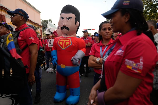 A person dressed as Super Mustache, a character depicting President Nicolas Maduro as a superhero, stands outside of Miraflores Palace a pro-government rally, days ahead of Maduro's presidential inauguration for a third term in Caracas, Venezuela, Wednesday, Jan 8, 2025. (AP Photo/Ariana Cubillos)