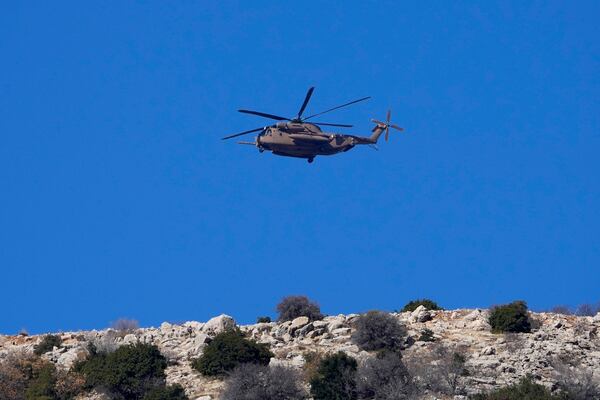 An Israeli Air Force Black Hawk helicopter flies over Mount Hermon near the so-called Alpha Line that separates the Israeli-controlled Golan Heights from Syria, viewed from the town of Majdal Shams, Tuesday, Dec. 17, 2024. (AP Photo/Matias Delacroix)