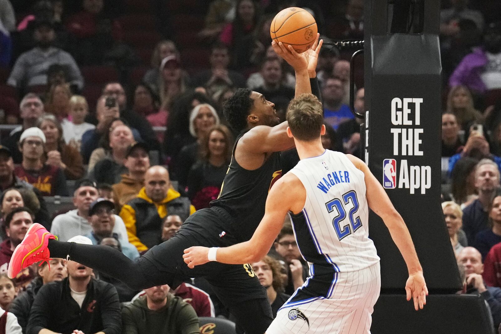 Cleveland Cavaliers guard Donovan Mitchell, left, goes to the basket past Orlando Magic forward Franz Wagner (22) in the first half of an NBA game, Friday, Nov. 1, 2024, in Cleveland. (AP PhotoSue Ogrocki)